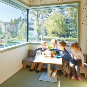 Spielende Kinder im Kindergarten Mariahilf / kigago Modulbauweisen (Paschinger Architekten) Massivholz