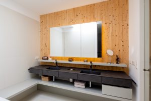 Von den Paschinger Architekten geplantes Badezimmer mit eigenen Waschbecken und Ablagemöglichkeiten