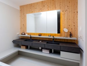 Von den Paschinger Architekten geplantes Badezimmer mit eigenen Waschbecken und Ablagemöglichkeiten