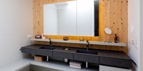 Von den Paschinger Architekten geplantes Badezimmer mit eigenen Waschbecken und Ablagemöglichkeiten