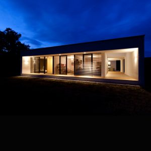 Stimmungsvolle, abendliche Außenansicht eines Bungalows der Paschinger Architekten