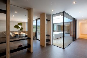 Ausblick in einen Innenhof mit großer Glasfront in einem Bungalow, der von Architekten geplant wurde