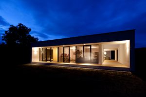 Stimmungsvolle, abendliche Außenansicht eines Bungalows der Paschinger Architekten