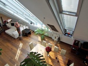 Innenansicht eines Dachgeschossausbaus in Wien mit großen Glasfenster (Paschinger Architekten)