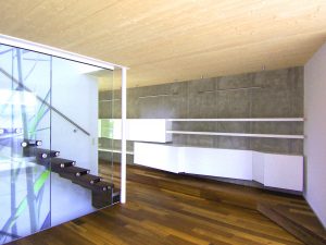 Innenansicht eines Doppelhauses an der alten Donau mit Holz-Glas-Stiege und besonderer Stauraum-Lösung an der Wand