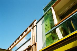 Außenansicht der unterschiedlichen Fassaden-Gestaltungen des Doppelhauses an der alten Donau (Paschinger Architekten). Glas und Holz im Kontrast