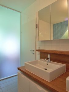 Bild des Bades mit integriertem Möbeldesign (Waschtisch) von einem Einfamilienhaus das von Architekten geplant wurde
