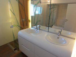 Bild des Bades mit integriertem Möbeldesign (Waschtisch & Dusche) von einem Einfamilienhaus das von Architekten geplant wurde