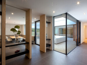 Ausblick in einen Innenhof mit großer Glasfront in einem Bungalow, der von Architekten geplant wurde